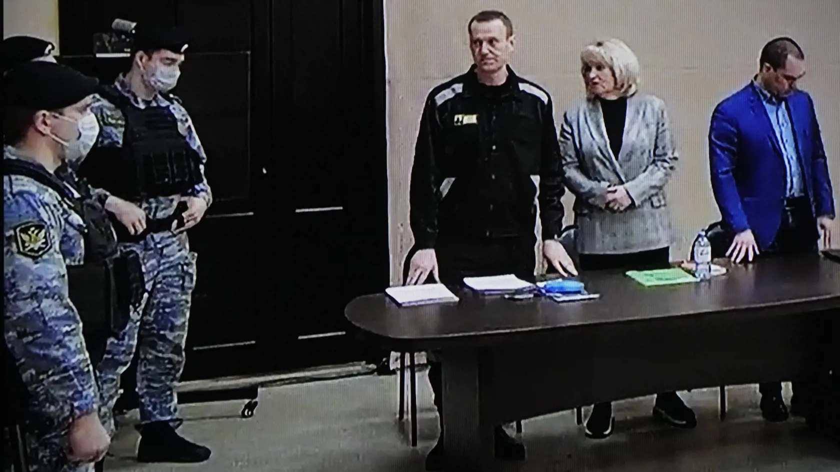 Na snímke z videa ruský opozičný líder Alexej Navaľnyj (uprostred) stojí vedľa svojich advokátov počas videolinku na súde v meste Pokrov, 100 km východne od Moskvy 22. marca  2022.