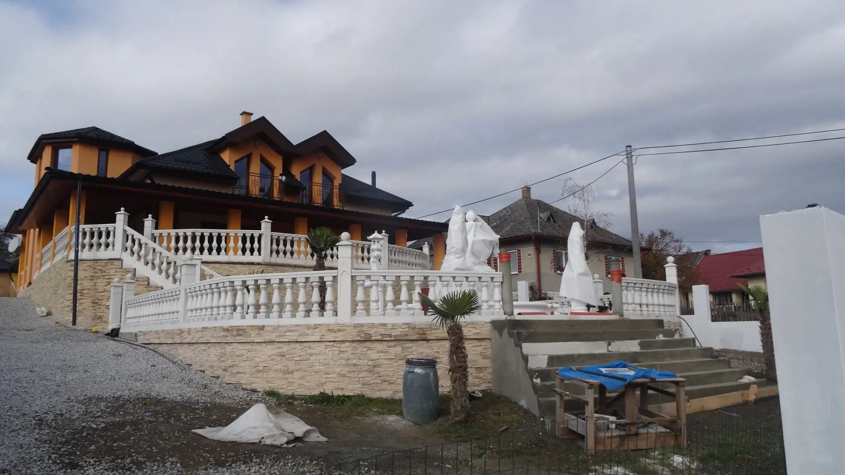 V Žehre si Rómovia budujú aj takéto zvláštne domy s velikánskym schodiskom a fontánou. Na otázku kde pracujú majitelia nám miestni prezradili, že sú to "bankári", ktorí požičiavajú osadníkom peniaze. Neprehliadnuteľné sú palmy v popredí.