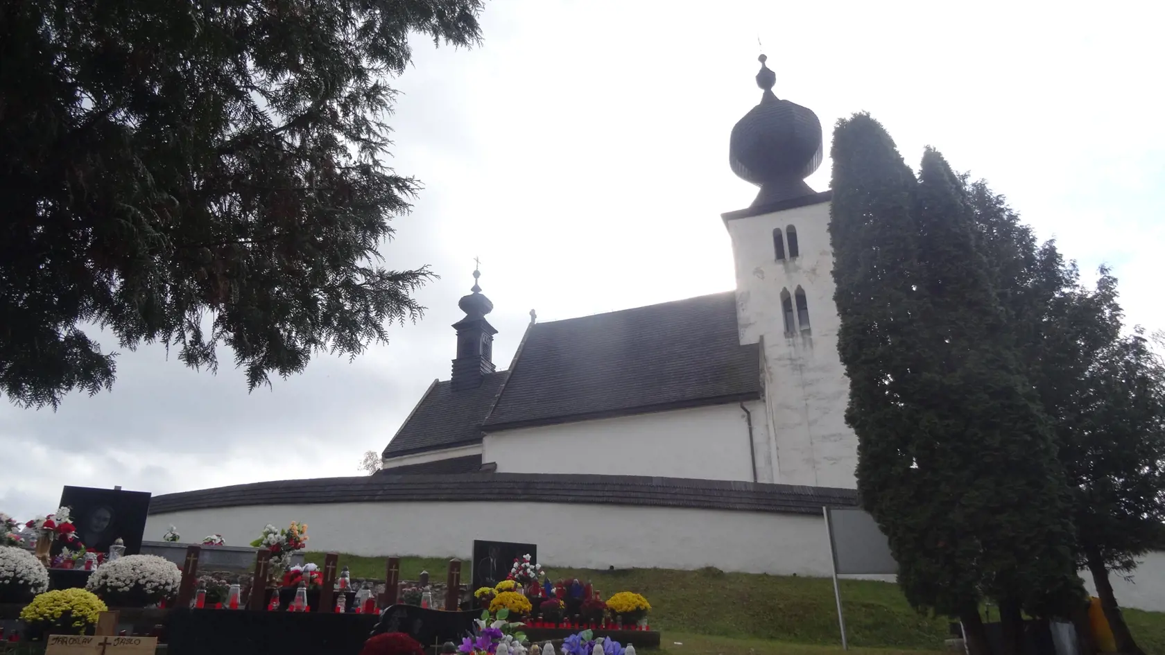 Pohľad na kostol narúšajú mohyly na cintoríne v Žehre.
