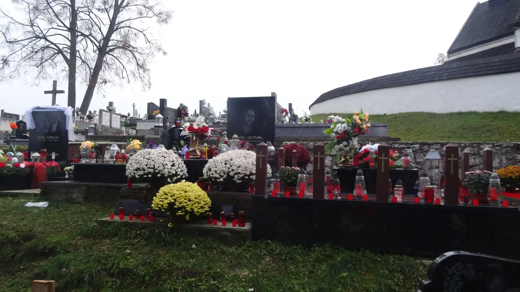Na obrovských mohylách sa kopí hromada plastových sviečok, kahancov a umelých kvetov.