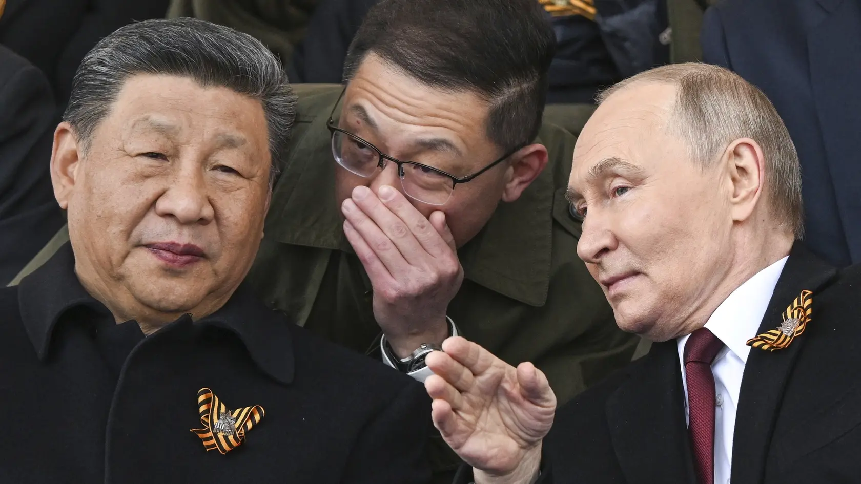 Na snímke vpravo ruský prezident Vladimir Putin a čínsky prezident Si Ťin-pching sa rozprávajú počas sledovania vojenskej prehliadky pri príležitosti 80. výročia konca druhej svetovej vojny v Európe v Moskve 9. mája 2025.