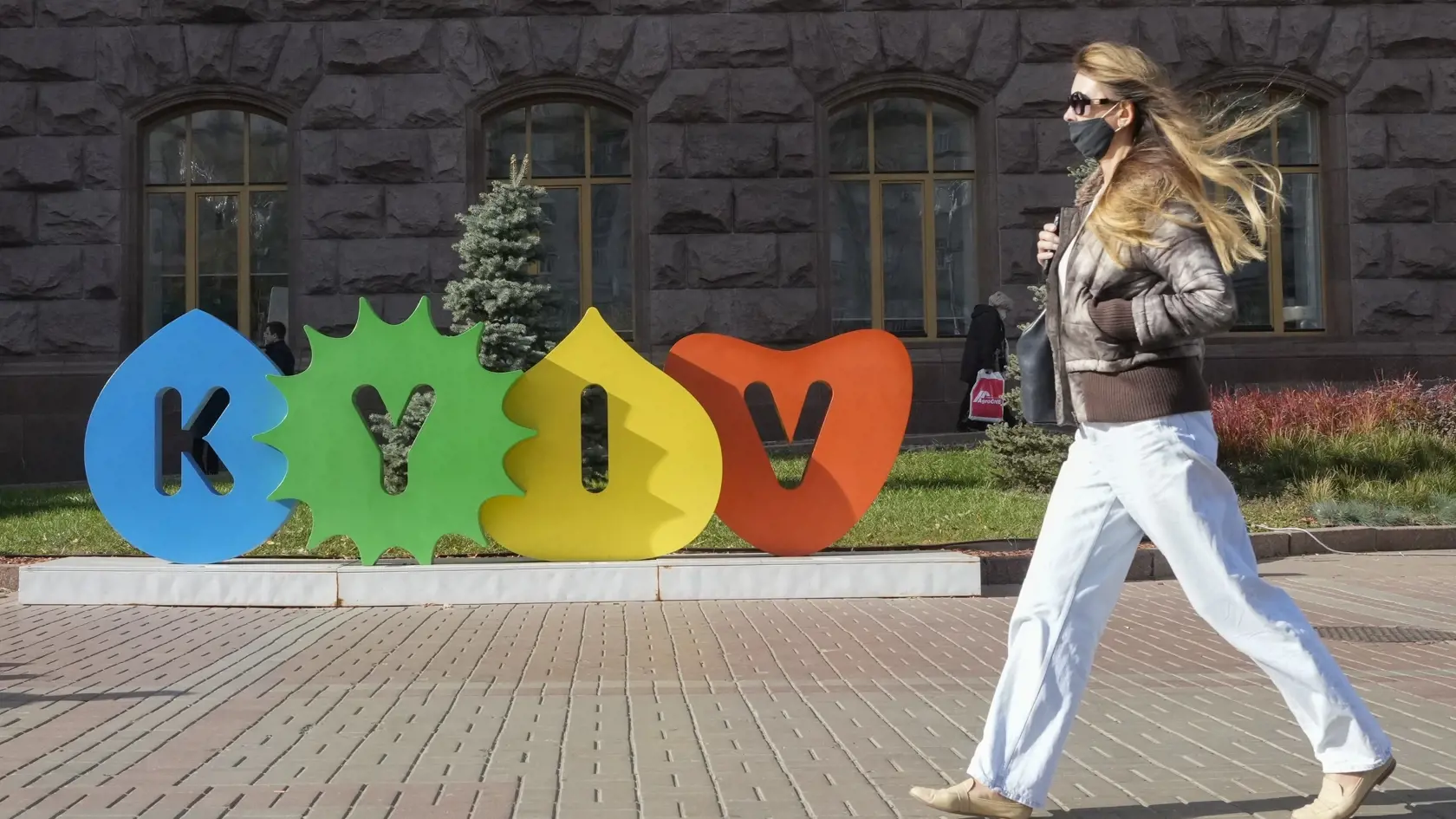 Žena s ochranným rúškom kráča po ulici v Kyjeve 21. októbra 2021.
