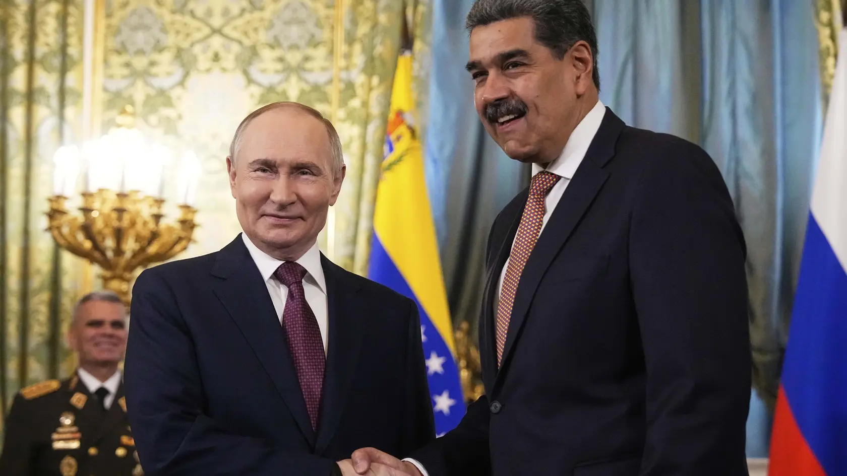 Ruský prezident Vladimir Putin (vľavo) a venezuelský prezident Nicolás Maduro si podávajú ruky počas stretnutia.