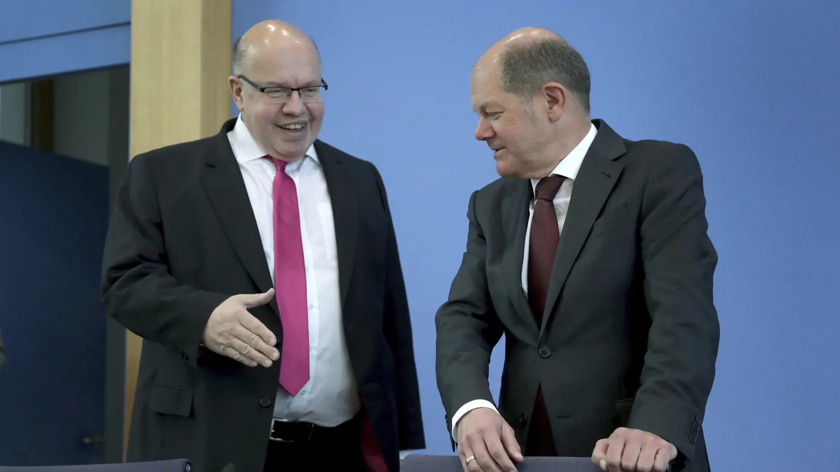 Nemecký minister hospodárstva  Peter Altmaier (vľavo) a nemecký minister financií  Olaf Scholz sa rozprávajú pred tlačovou konferenciou v Berlíne.