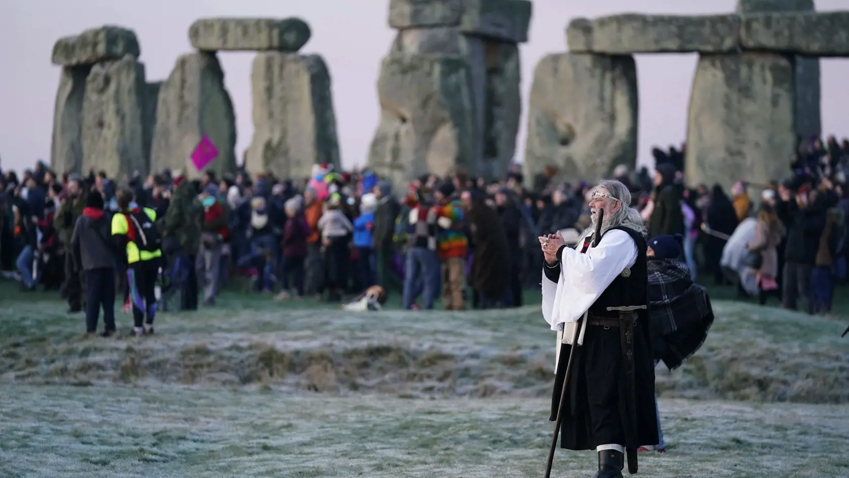 KK33 Stonehenge - Ľudia sa zhromažďujú na slávnostný obrad zimného slnovratu po najdlhšej noci roka v pravekom komplexe Stonehenge blízko Amesbury v južnom Anglicku 22. decembra 2021. Zimný slnovrat je astronomický termín pre okamih, keď sa Slnko na oblohe najviac vzdiali od svetového rovníka smerom na juh. Stonehenge postavili pred 4000 až 5000 rokmi a patrí medzi najznámejšie svetové kultúrne pamiatky. FOTO TASR/AP
People take part in the winter solstice celebrations as the sun rises, at the S