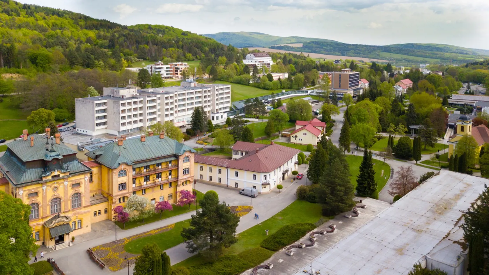 Kúpele z leteckého pohľadu. Vľavo liečebný dom Astória, za ním Ozón a vpravo dole je kolonáda, jediná na Slovensku, ukrýva 8 prírodných liečivých prameňov. 