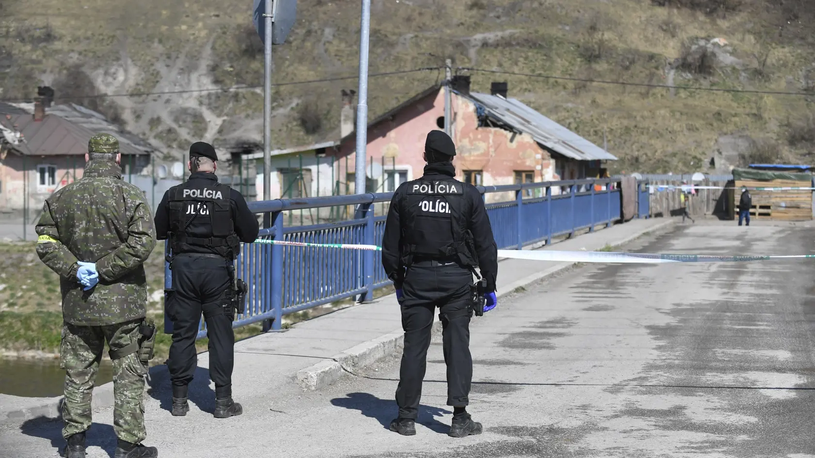 Vláda SR v súvislosti so zastavením šírenia ochorenia COVID-19 uzavrela päť osád v okrese Spišská Nová Ves. Pozitívne prípady zaznamenali v piatich osadách, tri z nich sú v Krompachoch, ďalšie evidujú v blízkych obciach Žehra a Bystrany. Na snímke polícia a vojak stráži uzavretú osadu v Krompachoch 9. apríla 2020. FOTO TASR – František Iván