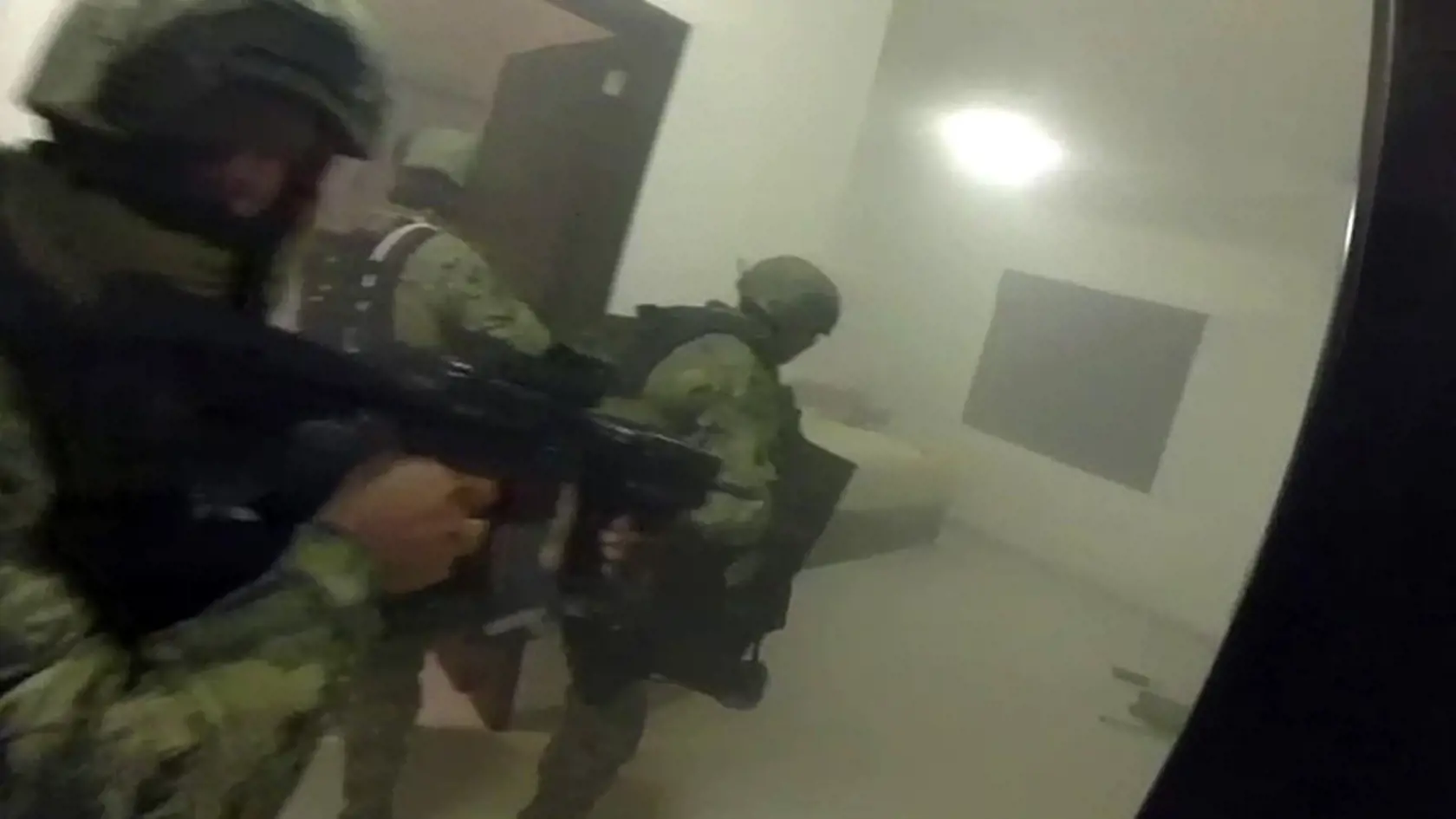 This frame-grab taken from Jan. 8, 2016 video released by Mexico's presidential press office, shows Mexican navy marines storming a home during the operation to recapture Mexico's most wanted drug kingpin, Joaquin "El Chapo" Guzman in Los Mochis, Mexico. Mexico has begun the process of extraditing Guzman to the United States, where he faces drug-trafficking charges, but that could take "a year or longer" because of legal challenges, said the head of Mexico's extradition office, Manuel Merino. He