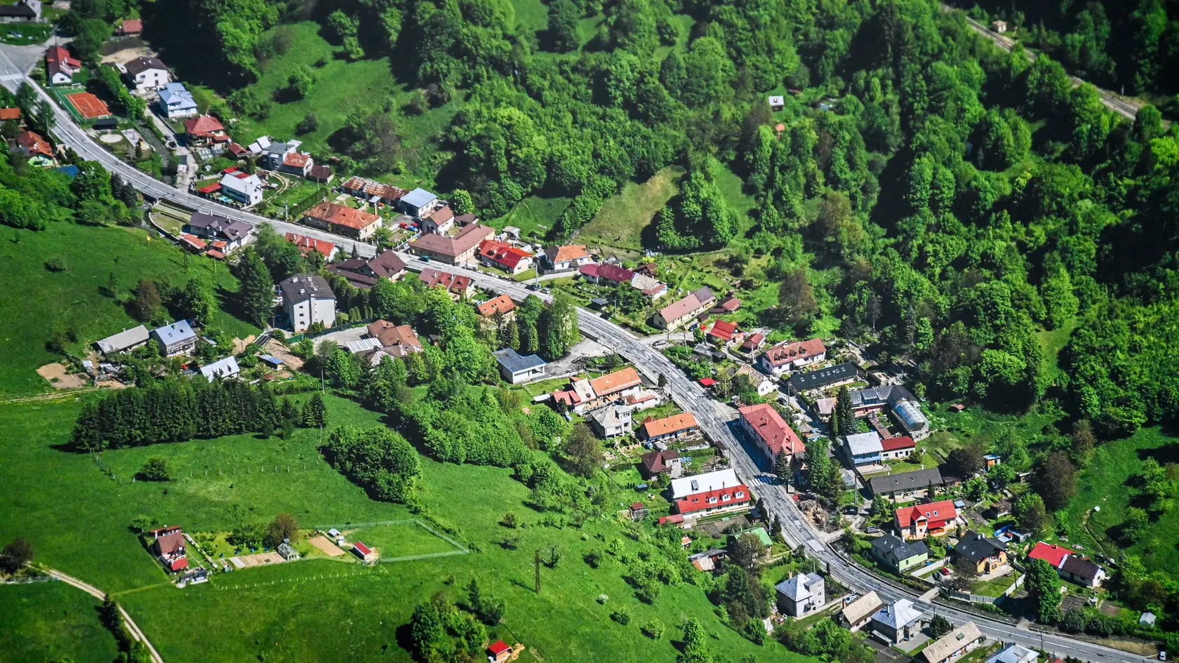 Vtáčí pohľad na obec Dolný Harmanec, ktorá leží v úzkej Harmaneckej doline na styku Veľkej Fatry s Kremnickými vrchmi.