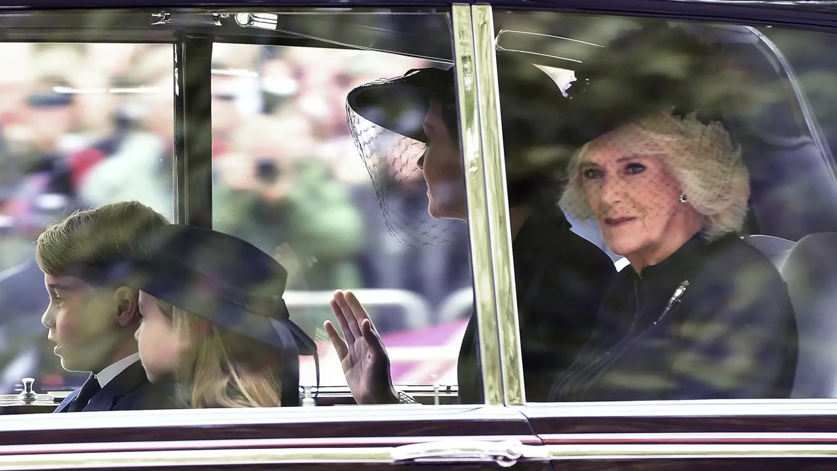 Britská kráľovná manželka Kamila (vpravo), britská princezná z Walesu Catherine (vpravo v pozadí) a jej dve deti - princezná Charlotte (vľavo) a princ George prichádzajú v aute na štátny pohreb britskej kráľovnej Alžbety II.