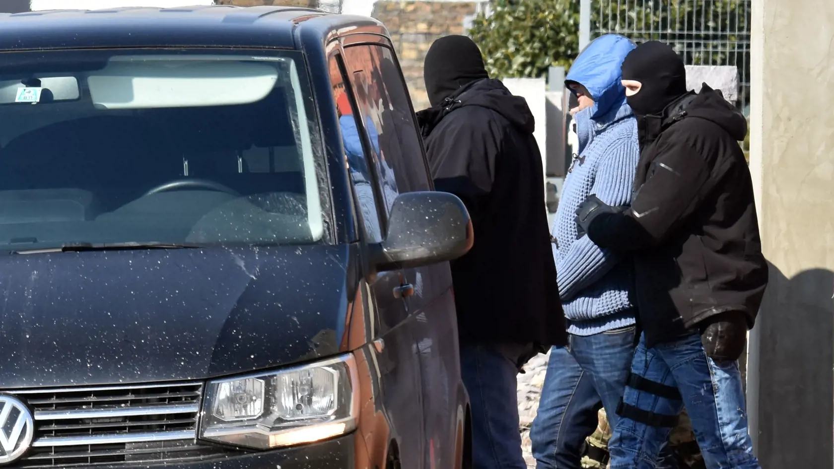 V súvislosti s raziami na Zemplíne, ktoré sú spájané s vraždou novinára Jána Kuciaka a jeho priateľky, bude pravdepodobne zaistených do desať osôb. Následne budú s nimi vykonané úkony a rozhodne sa o ďalšom postupe. Pred jedným z michalovských domov na Kavarnianskej ulici to novinárom povedal vo štvrtok 1. marca 2018 policajný prezident Tibor Gašpar. Na snímke policajti sprevádzajú zadržaného muža po policajnej razii v dome na  Kavarnianskej ulici v Michalovciach 1. marca 2018. FOTO TASR - Roman