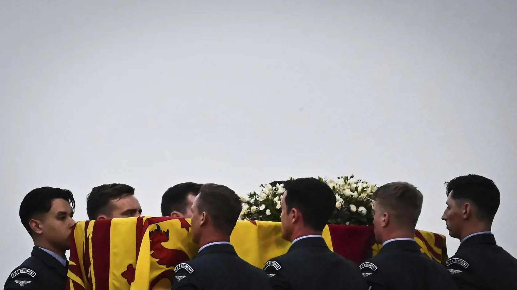 Príslušníci Britského kráľovského letectva (RAF) vynášajú z lietadla RAF C17 rakvu s telesnými pozostatkami zosnulej britskej kráľovnej Alžbety II. po pristátí na letisku RAF Northolt v Londýne 13. septembra 2022. Rakvu britskej kráľovnej Alžbety II. previezli dnes letecky zo Škótska do Londýna.