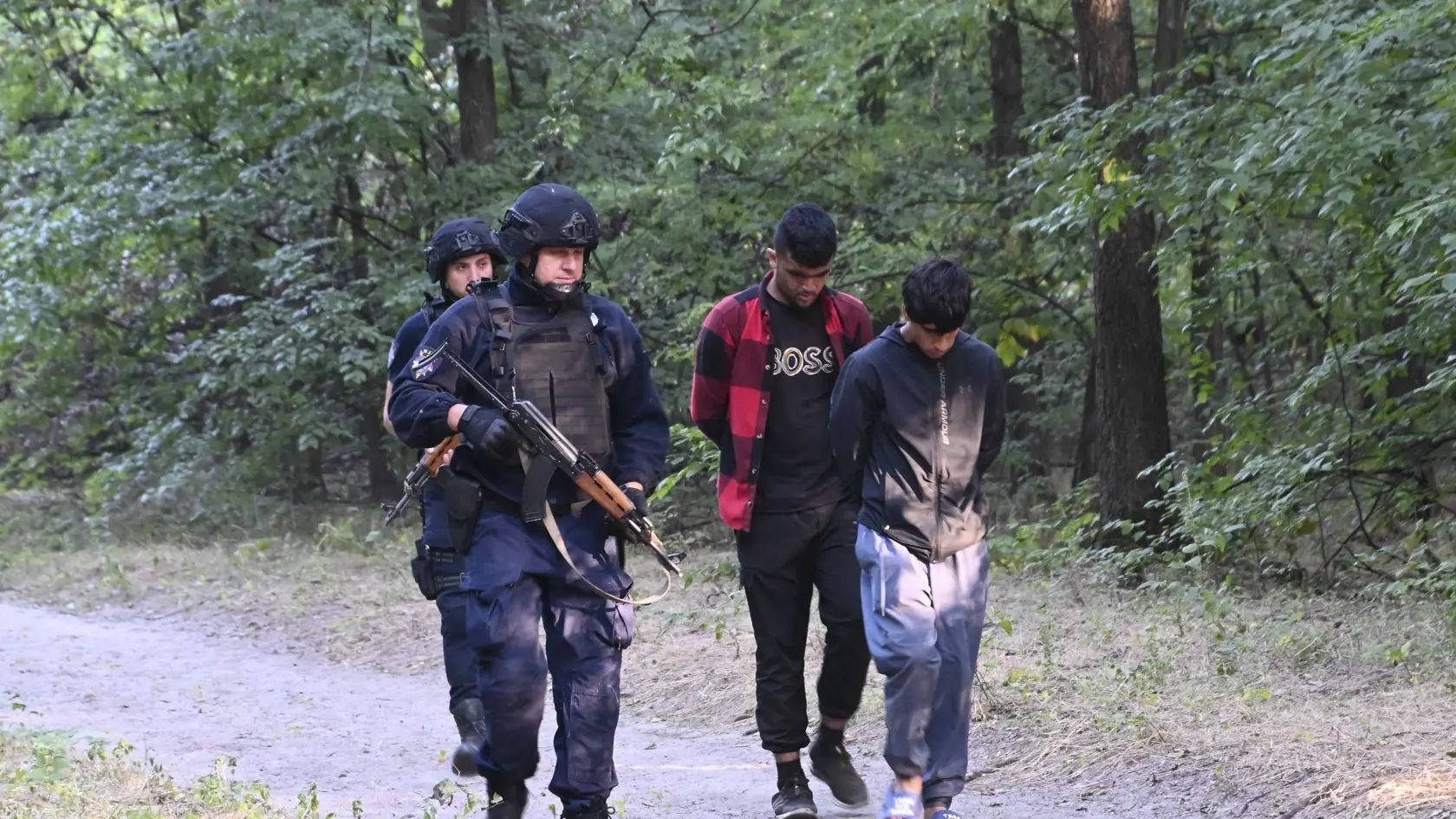 WA 36 - Srbskí policajti vedú zadržaných migrantov  v blízkosti hraníc s Maďarskom v utorok 12. septembra 2023.