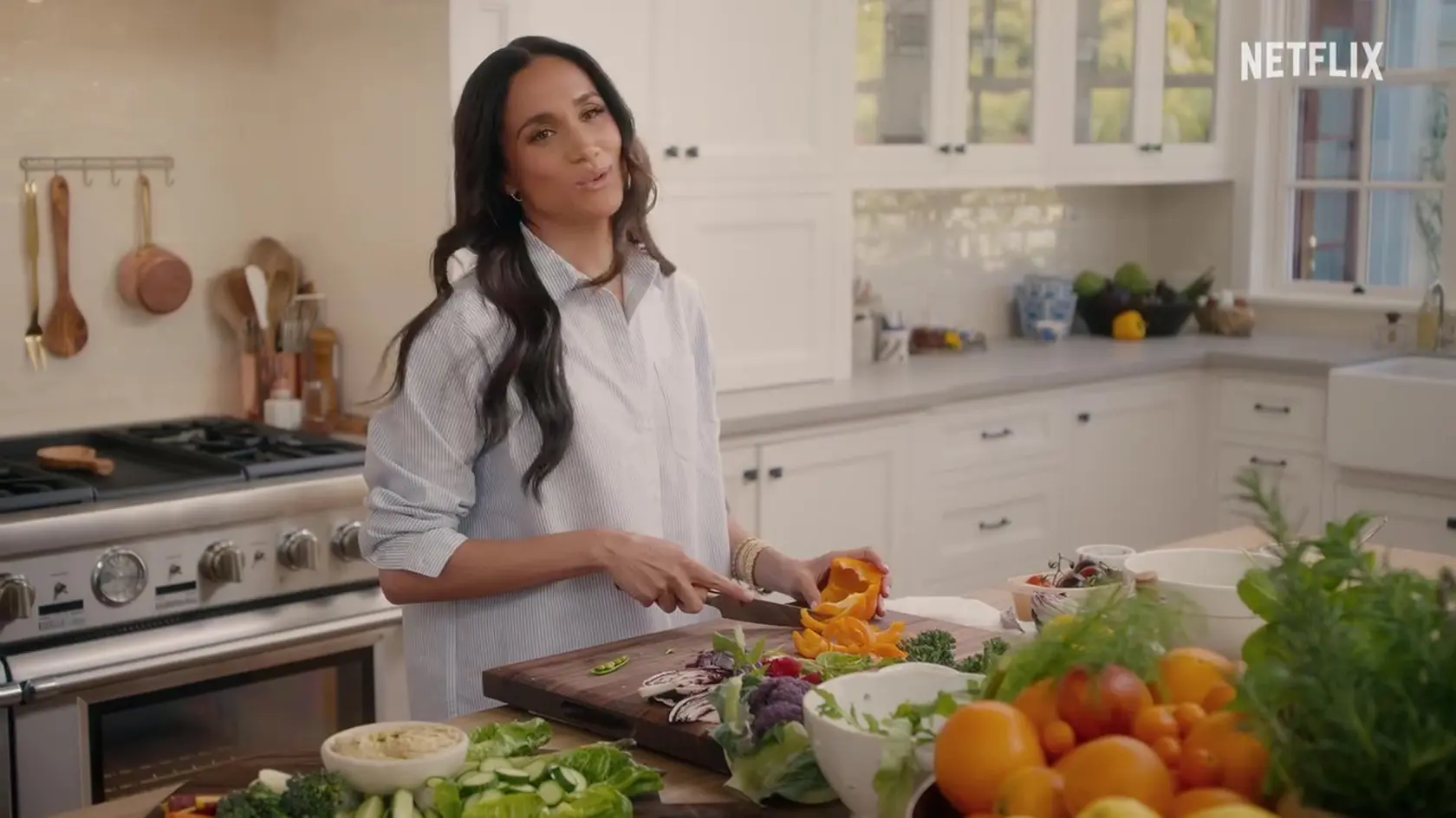 Meghan Markle má vlastnú kulinársku šou na Netflixe. Kým krája zeleninu nožom za 160 eur, na zápästí jej visia luxusné zlaté hodinky Cartier Tank Francaise za 26-tisíc eur a zlatý náramok rovnakej značky za 5,5 tisíca eur.