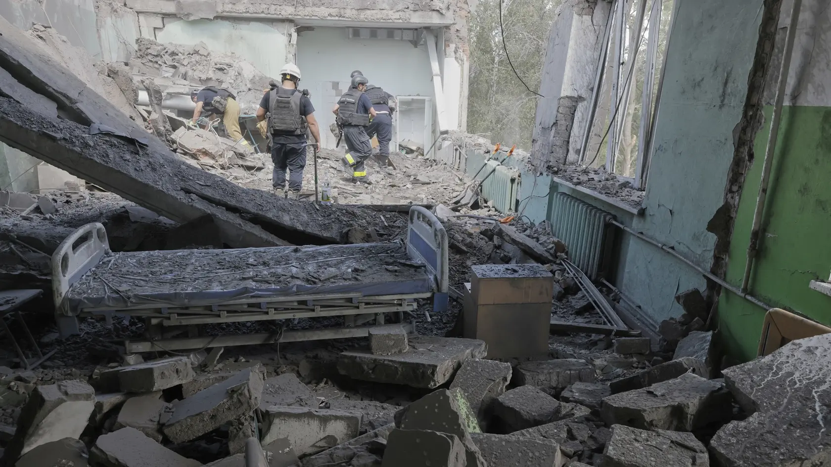 Záchranári odstraňujú ruiny  v mestskej nemocnici po zásahu ruskej leteckej bomby v meste Charkov.