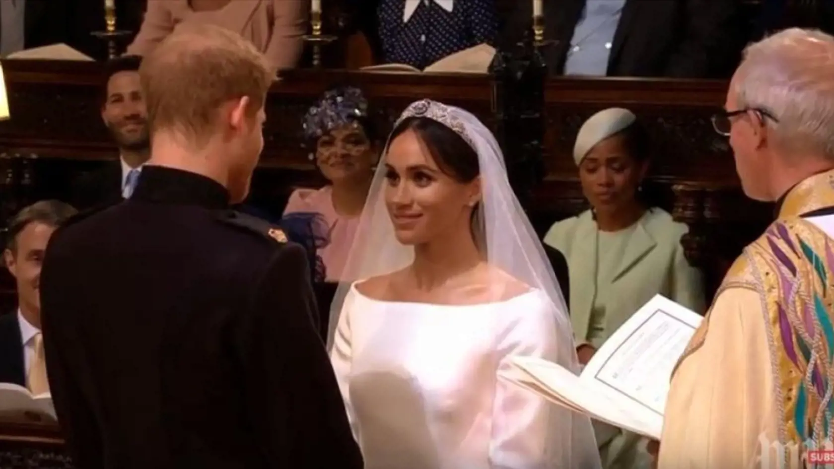 Harry a Meghan stoja pri vysokom oltári a čítajú si sľuby.