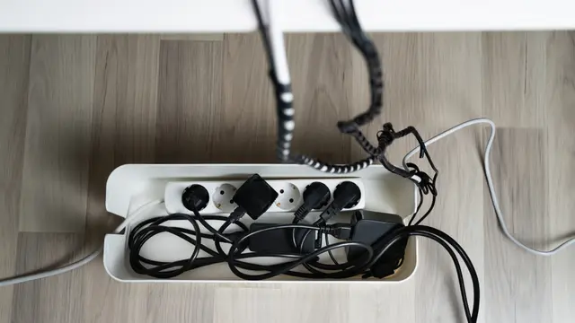 High Angle View Of Cable Management Box With Cables On Hardwood Floor